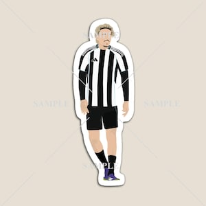 May include: A sticker featuring a stylized illustration of a soccer player in a black and white striped jersey, black shorts, and black socks. The player is wearing purple and black cleats. The Adidas logo is visible on the jersey.