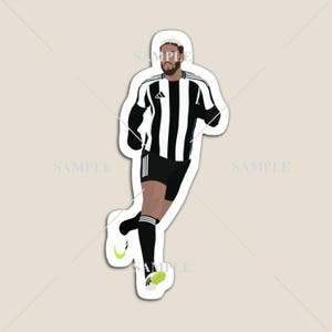 May include: A sticker featuring a stylized illustration of a soccer player in a black and white striped jersey, black shorts, and black socks. The player is running, with a light green swoosh on the shoe.