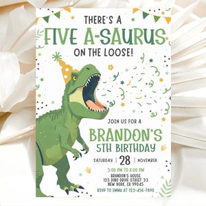 May include: A birthday party invitation with a green dinosaur wearing a party hat. The invitation reads "THERE'S A FIVE A-SAURUS ON THE LOOSE!" and invites guests to Brandon's 5th birthday party on November 28th.