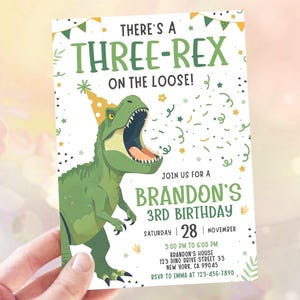 May include: A birthday invitation featuring a green dinosaur wearing a party hat. The text says "THERE'S A THREE-REX ON THE LOOSE!" and invites guests to Brandon's 3rd birthday party on November 28th.