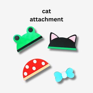 May include: Four colorful cat attachments for a cat toy. The attachments are a green frog, a black cat, a red and white mushroom, and a blue bow.