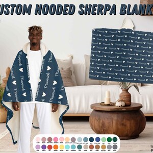 K&ouml;nnte beinhalten: Eine marineblaue Kapuzen-Sherpa-Decke mit einem wei&szlig;en Herzen und dem Namen "Maverick", der sich auf dem Stoff wiederholt. Die Decke wird von einer Person getragen. Die Decke ist in verschiedenen Farben erh&auml;ltlich.