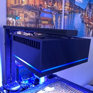 May include: A black aquarium light fixture with a blue LED strip. The light is mounted on a black metal frame and has a white plastic cover.