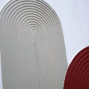 Peut inclure: Œuvre d'art abstraite avec des formes semi-circulaires texturées en gris et bordeaux sur fond blanc. Le design minimaliste met en valeur la texture et le contraste des couleurs, idéal pour la décoration intérieure contemporaine. Mesures en centimètres.