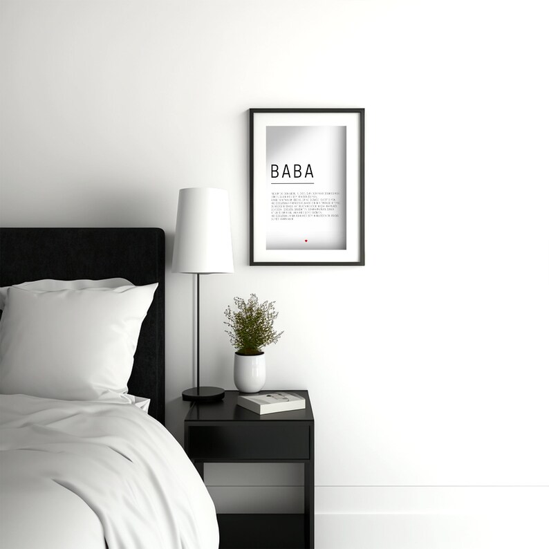 May include: A black and white framed print with the word "BABA" in bold text. The print is hanging on a white wall above a black nightstand with a white lamp and a small potted plant.