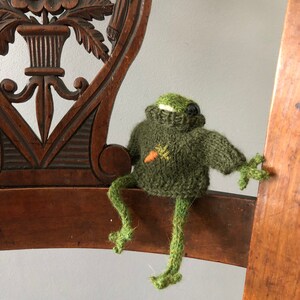 Spring knitted frog in a sweater with embroidered carrot