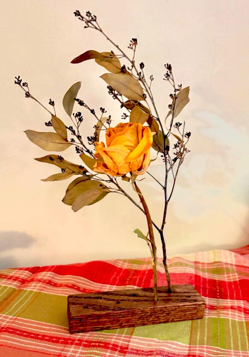 Peut inclure: Une seule rose jaune s&eacute;ch&eacute;e avec des feuilles et des branches d'eucalyptus s&eacute;ch&eacute;es dans un vase en bois.