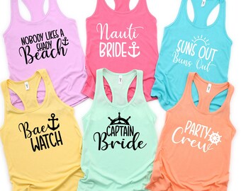 May include: Six tank tops with nautical themed text and graphics. The tank tops are in various colors, including pink, blue, yellow, and green. The text on the tank tops includes "Nobody Likes a Shady Beach", "Nauti Bride", "Suns Out Buns Out", "Bae Watch", "Captain Bride", and "Party Crew".