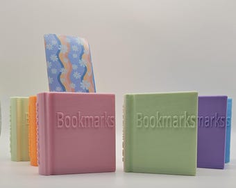 May include: Five small, colorful bookends with the word "Bookmarks" printed on them. The bookends are in shades of pink, green, purple, orange, and yellow.