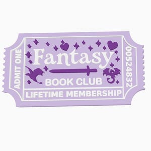 May include: A light purple ticket with the words "Fantasy Book Club" and "Lifetime Membership". The ticket has a decorative border and features a sword, hearts, and a dragon illustration. The ticket reads "Admit One" and has a serial number.