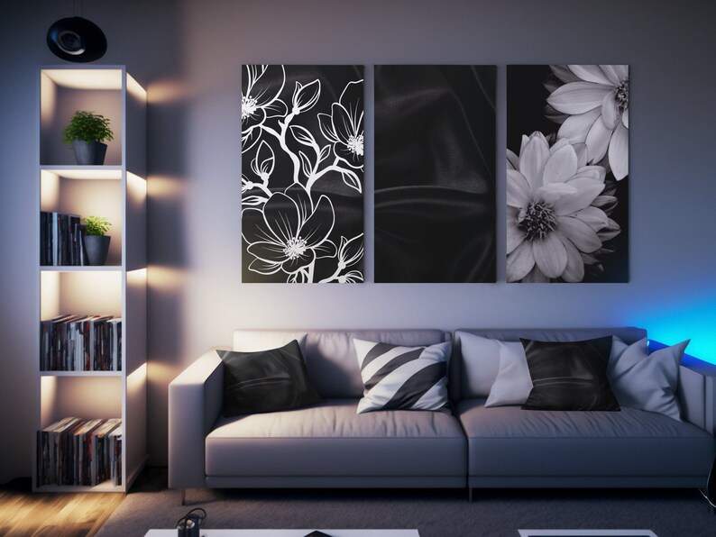 May include: A modern living room featuring a gray sofa with decorative pillows and three black and white floral wall art pieces. A white bookshelf with plants and books is on the left. The room is illuminated by soft lighting.