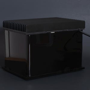 Puede incluir: Un dispositivo electr&oacute;nico negro y rectangular con una parte superior acanalada y una superficie brillante y reflectante. Un cable negro se extiende desde el lateral. El dispositivo est&aacute; sobre un fondo gris oscuro.