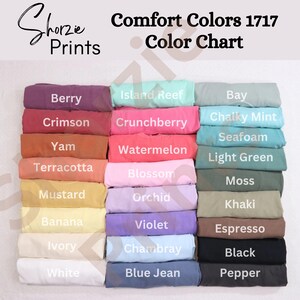 May include: A color chart displays a variety of Comfort Colors 1717 t-shirt hues. The chart includes colors like Berry, Crimson, Yam, Terracotta, Mustard, Banana, Ivory, and White. Other colors include Island Reef, Crunchberry, Watermelon, Blossom, Orchid, Violet, Chambray, and Blue Jean.
