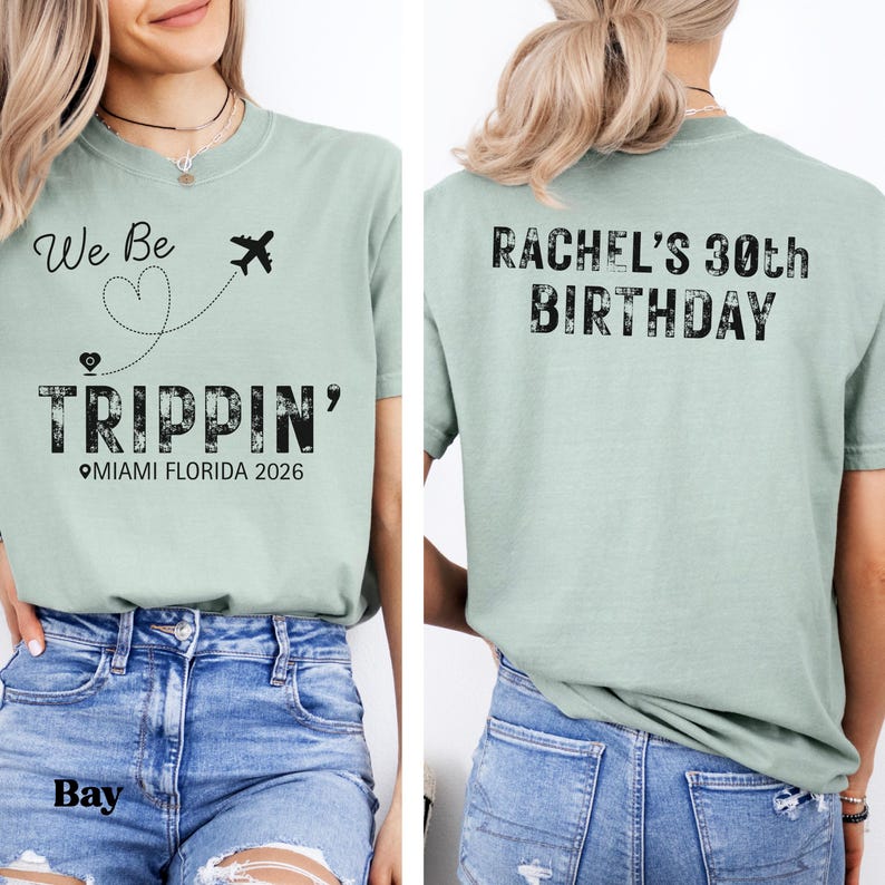 May include: A light green t-shirt with the text "We Be Trippin'" and a heart-shaped dotted line with a plane graphic. The text "Miami Florida 2026" is below. The back of the shirt says "Rachel's 30th Birthday".