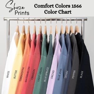 Op de afbeelding: Kleurenkaart met 11 verschillende kleuren T-shirts van Comfort Colors 1566. De kleuren zijn: Wit, Boter, Terracotta, Watermeloen, Karmijnrood, Lichtgroen, Blauwe spar, Orchidee, Jeansblauw, Denim, Peper en Zwart.