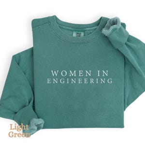 May include: A light green sweatshirt with the text "WOMEN IN ENGINEERING" printed in white on the front.