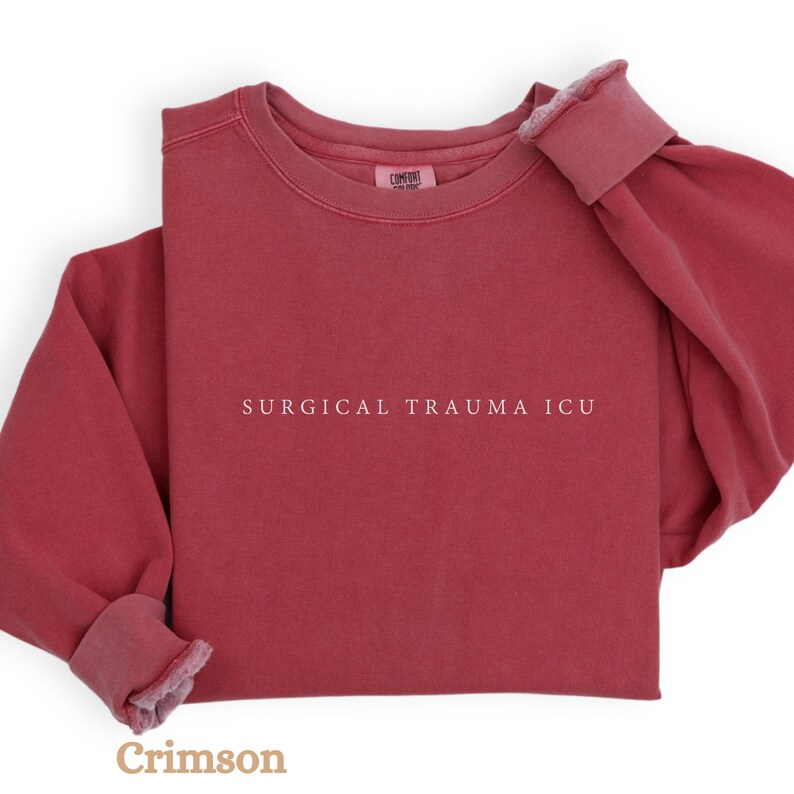 May include: Crimson red sweatshirt with the text "SURGICAL TRAUMA ICU" printed in white.