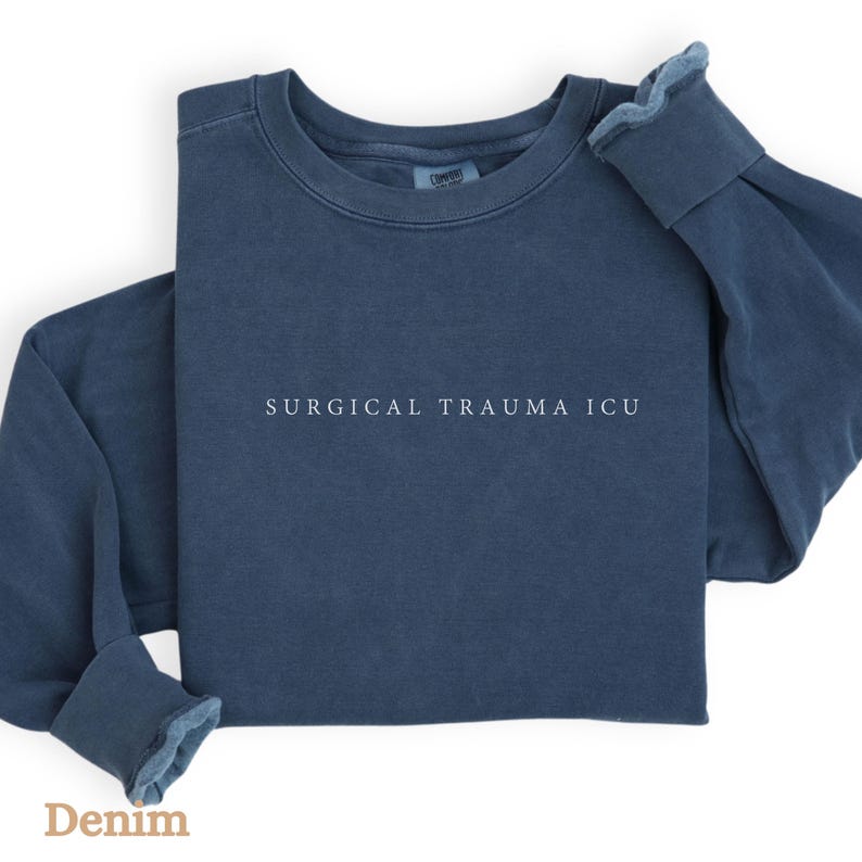 May include: A dark blue sweatshirt with the text "SURGICAL TRAUMA ICU" printed in white on the front.