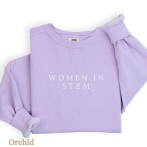 May include: A lavender sweatshirt with the text "Women in STEM" printed in white on the front.