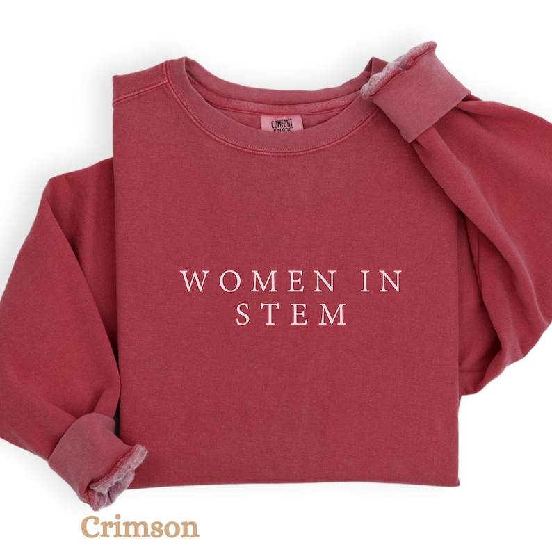 May include: Crimson red sweatshirt with the text "WOMEN IN STEM" printed in white.