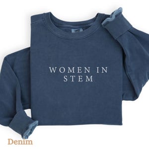 May include: A dark blue sweatshirt with the text "WOMEN IN STEM" printed in white on the front.