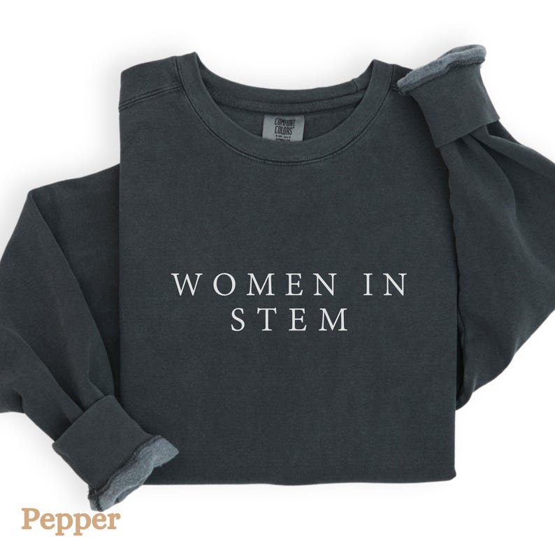 May include: A dark grey sweatshirt with the text "WOMEN IN STEM" printed in white on the front.