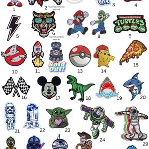 May include: Collection of embroidered patches featuring cartoon characters and pop culture icons. Includes Sonic the Hedgehog, a pirate skull, an astronaut, Lightning McQueen, a lightning bolt, a tiger, Mario, Luigi, Teenage Mutant Ninja Turtles, a Ghostbuster, a rocket, a robot, a Pokeball, Pikachu, pizza, checkered flags, Mickey Mouse, a T-Rex, sharks, a Stormtrooper, R2-D2, Baby Yoda, Buzz Lightyear, an astronaut on a skateboard, C-3PO, Darth Vader, BB-8, Woody, and a Triceratops.