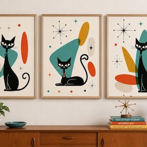 Könnte beinhalten: Ein Set aus drei gerahmten Wandbildern mit schwarzen Katzen im Mid-Century-Stil. Jeder Druck zeigt eine schwarze Katze mit stilisierten geometrischen Formen in Petrol, Orange und Gelb sowie schwarzen Sternenmustern auf cremefarbenem Grund.