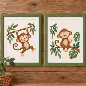 Puede incluir: Dos cuadros de pared con ilustraciones de monos marrones en una selva. El cuadro izquierdo muestra un mono colgado de una rama, mientras que el derecho muestra un mono sentado en una rama sosteniendo un plátano amarillo. Marcos verdes.