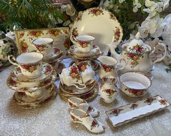 Peut inclure: Un service à thé vintage avec des motifs floraux, comprenant une théière, un sucrier, un pot à crème et quatre tasses et soucoupes à thé. L'ensemble est en porcelaine fine et présente un délicat motif floral avec des accents dorés.