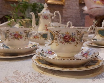May include: A vintage tea set with floral patterns. The set includes a teapot, a sugar bowl, a creamer, and four teacups and saucers.