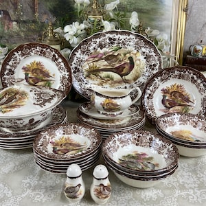 Könnte beinhalten: Eine Sammlung von Vintage-Geschirr aus braun-weißer Keramik mit Fasanen-Illustrationen. Das Set umfasst Teller, Schalen, eine Servierschüssel, eine Sauciere sowie Salz- und Pfefferstreuer. Die Teller haben einen gewellten Rand.