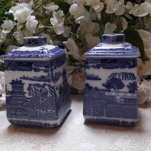 Peut inclure: Deux pots carrés en céramique bleu et blanc avec un motif chinois traditionnel. Les pots ont un couvercle et sont décorés d'un motif floral bleu et blanc.