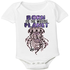 May include: White baby onesie with short sleeves and a purple and black graphic of a jellyfish with the text "Born on the wrong planet".