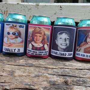 Może przedstawiać: Pięć aluminiowych puszek po napojach z personalizowanymi osłonami. Każda osłona zawiera zdjęcie dziecka i tekst, taki jak "Cheers to 21 Years!" i "Finally 21". Osłony są niebieskie, bordowe i czerwone.