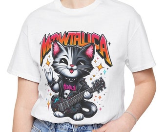 May include: White t-shirt featuring a black and white cartoon cat playing a guitar. The cat is wearing a black leather jacket with the word "Metallica" on it. The text "Metallica" is in a colourful gradient font above the cat.