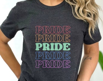 May include: A dark gray t-shirt with the word "PRIDE" repeated five times in a rainbow color scheme. Each word is outlined in a different color, creating a stacked rainbow effect.