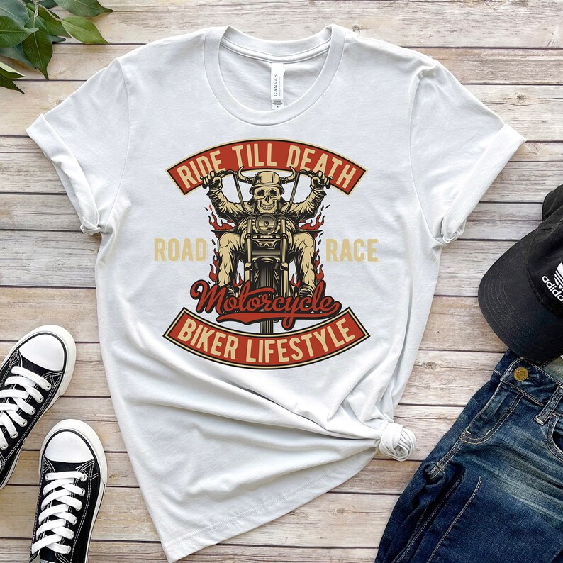 May include: White t-shirt with a graphic of a skeleton riding a motorcycle. The graphic includes the text "Ride Till Death", "Road", "Race", "Motorcycle", and "Biker Lifestyle".