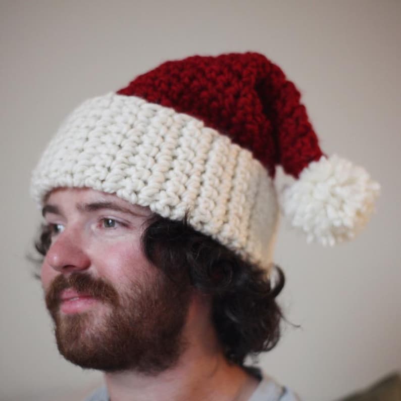 May include: A white and red crocheted Santa hat with a white pom-pom on top.