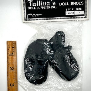 May include: A pair of black doll shoes in a plastic bag with a label that reads "Tallina's Doll Shoes Doll Supplies Inc. Style 74052 Size 4 Made in Taiwan R.O.C."
