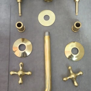 May include: Gold-toned shower faucet set with a shower head, two handles, and various connecting pieces.