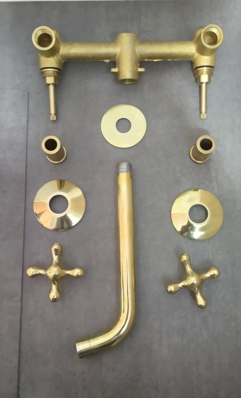 May include: Gold-toned shower faucet set with a shower head, two handles, and various connecting pieces.