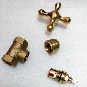 Peut inclure: Un ensemble de robinetterie en laiton comprenant une poign&eacute;e en croix &agrave; quatre branches, un corps de vanne en Y marqu&eacute; 1/2, un capuchon filet&eacute; en d&ocirc;me et une cartouche avec un joint rouge, une bague blanche et un joint torique noir.