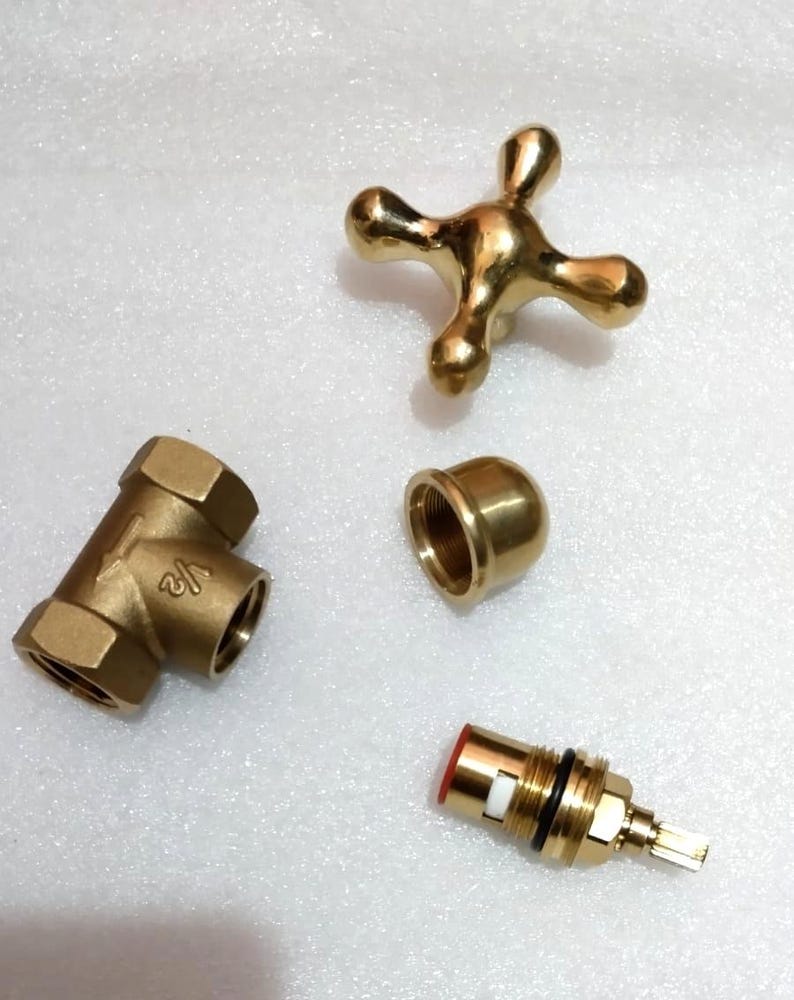 Peut inclure: Un ensemble de robinetterie en laiton comprenant une poign&eacute;e en croix &agrave; quatre branches, un corps de vanne en Y marqu&eacute; 1/2, un capuchon filet&eacute; en d&ocirc;me et une cartouche avec un joint rouge, une bague blanche et un joint torique noir.
