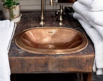Oval Hammered Copper Drop-In Bathroom Sink with a Warm Copper Finish.