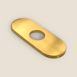May include: A gold-coloured, elongated oval plate with a circular hole in the centre. The plate has rounded edges and a smooth, metallic finish. The object is likely a decorative or functional hardware component.
