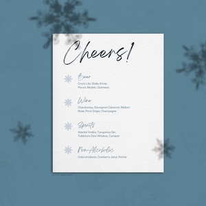 May include: A white card with the word "Cheers!" in blue cursive writing. The card lists different types of alcoholic and non-alcoholic beverages, including beer, wine, spirits, and non-alcoholic options. Each category is marked with a snowflake icon.