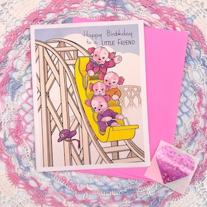 Tarjeta de cumpleaños perlada con sobre rosa y pegatina de corazón para fiesta en montaña rusa con cachorro rosa “Little Friend” de Heaven Sent