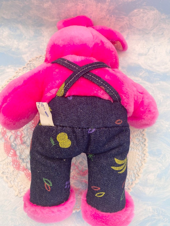 フルーティーなデニムオーバーオールを着たピンクのウサギの