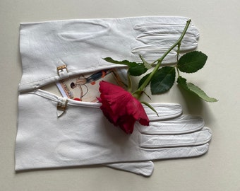 May include: A pair of white leather gloves with gold buckles, a red rose, and a vintage illustration card.